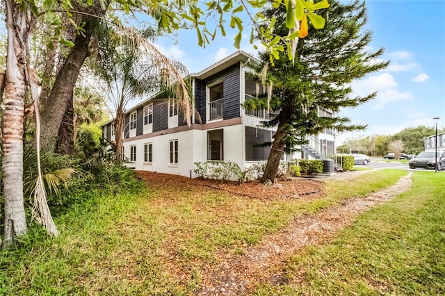 rear view of property with a yard and stucco siding