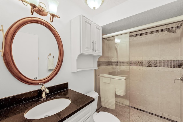 bathroom with a stall shower, vanity, and toilet