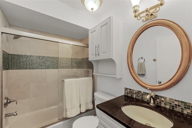 bathroom featuring enclosed tub / shower combo, vanity, toilet, and decorative backsplash