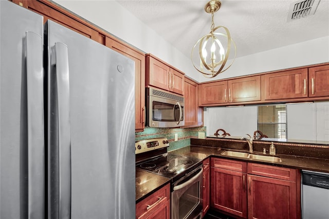 kitchen with stainless steel appliances, tasteful backsplash, visible vents, a sink, and a textured ceiling