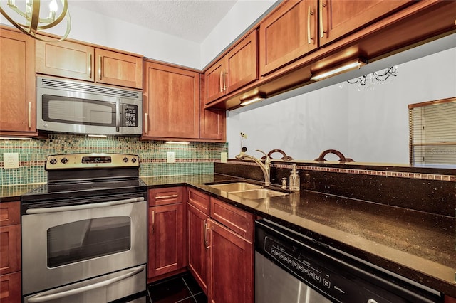 kitchen featuring a textured ceiling, stainless steel appliances, tasteful backsplash, and a sink