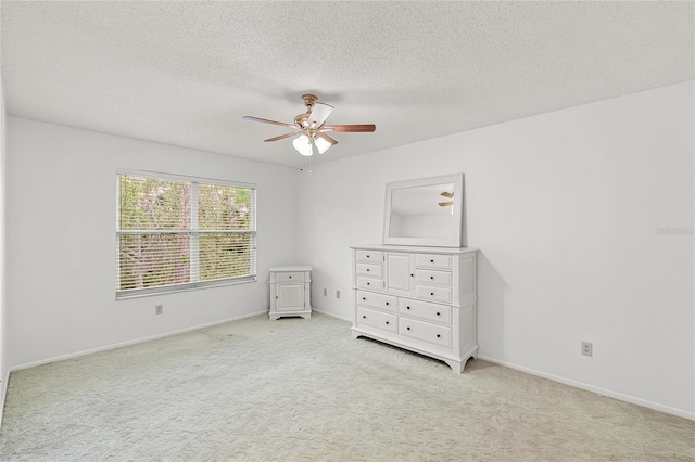 unfurnished bedroom featuring a textured ceiling, ceiling fan, carpet, and baseboards