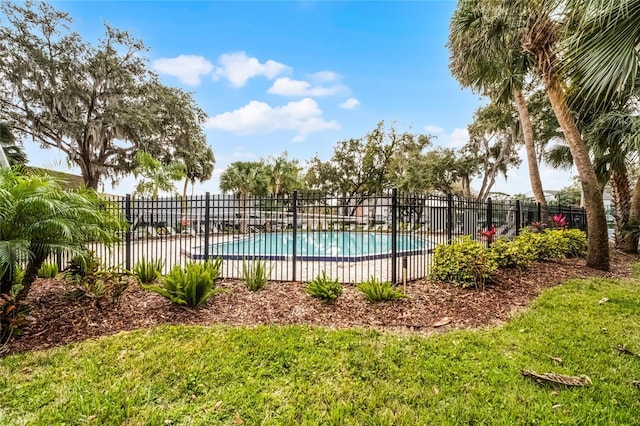 community pool featuring a lawn and fence