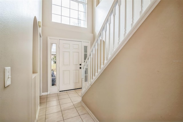 entrance foyer with a towering ceiling and light tile patterned floors