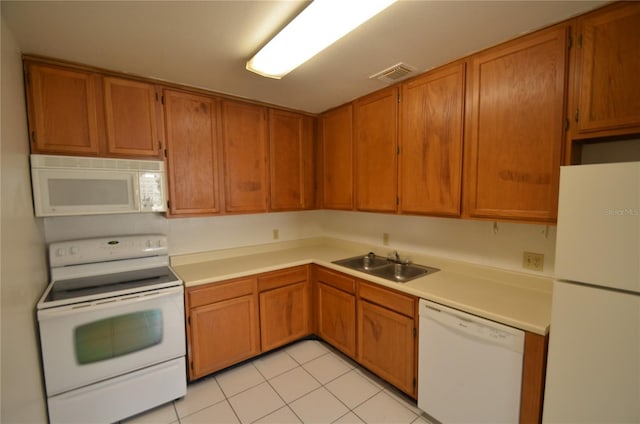 kitchen with white appliances, sink, and light tile patterned flooring