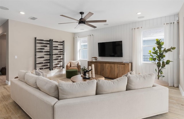 living room with light hardwood / wood-style floors and ceiling fan