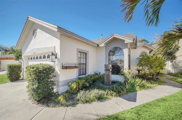 view of front of home featuring a garage, concrete driveway, and stucco siding