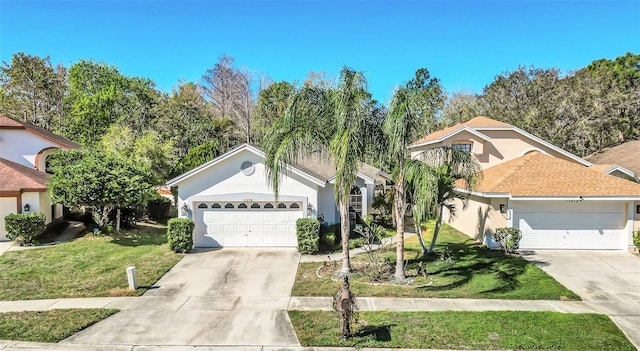 ranch-style home with concrete driveway, a front yard, an attached garage, and stucco siding