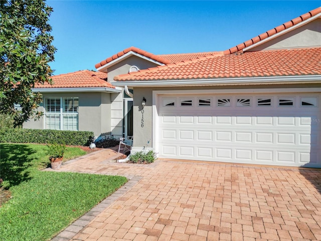 mediterranean / spanish house with a front lawn and a garage