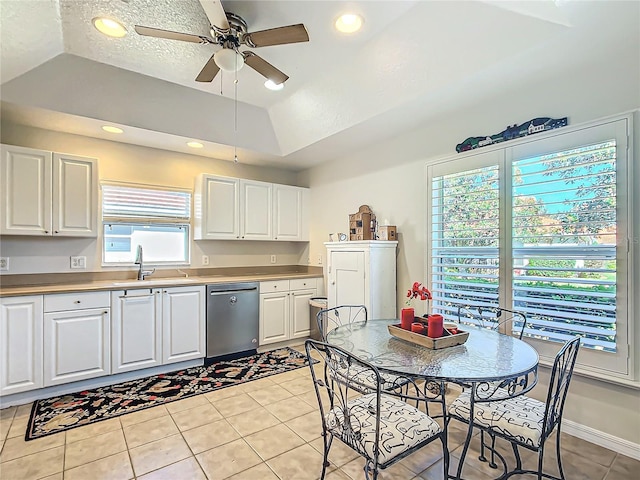 kitchen featuring light tile patterned floors, sink, white cabinetry, stainless steel dishwasher, and a raised ceiling