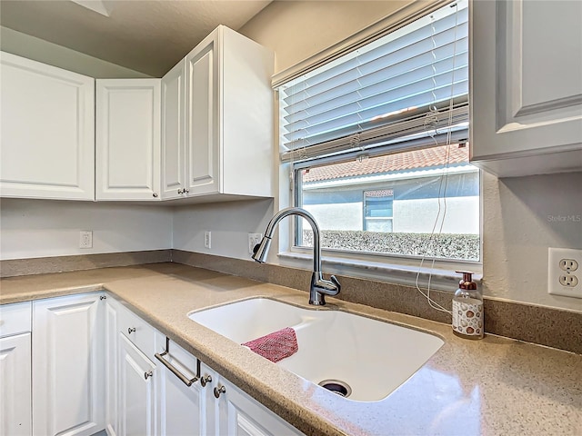 kitchen featuring sink and white cabinetry