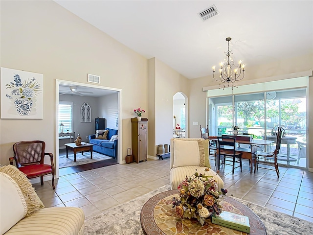tiled living room with high vaulted ceiling, a chandelier, and a wealth of natural light