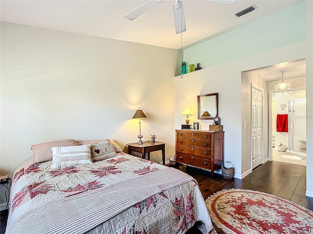 bedroom with dark hardwood / wood-style flooring, ensuite bath, and ceiling fan with notable chandelier