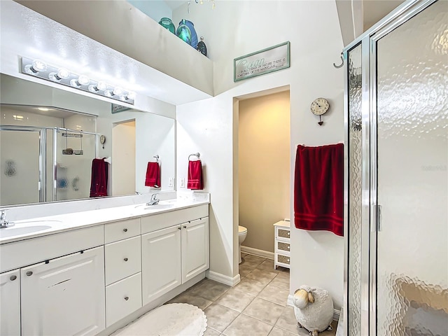 bathroom with tile patterned floors, toilet, a shower with door, and vanity