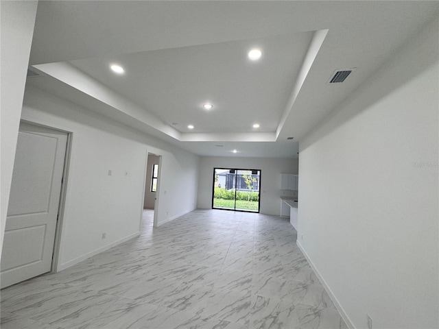 unfurnished living room featuring a tray ceiling