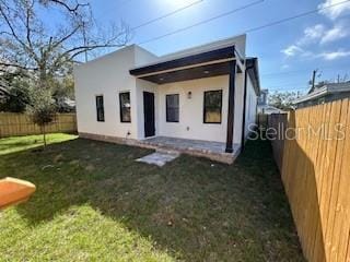 2604 E 11th Ave, Tampa, FL 33605 - rear view of property with a fenced backyard, stucco siding, and a yard