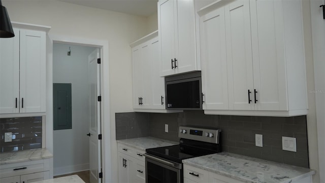 2604 E 11th Ave, Tampa, FL 33605 - kitchen featuring tasteful backsplash, electric stove, white cabinets, light stone countertops, and electric panel