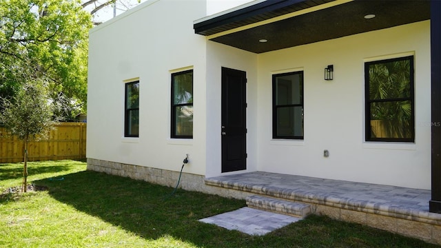 2604 E 11th Ave, Tampa, FL 33605 - property entrance with a lawn, stucco siding, and fence