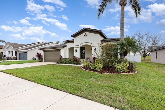 mediterranean / spanish-style home with an attached garage, concrete driveway, a front yard, and stucco siding