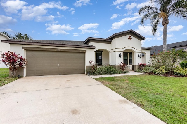 mediterranean / spanish-style home with a front lawn, concrete driveway, an attached garage, and stucco siding