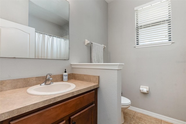 bathroom with toilet, tile patterned flooring, baseboards, and vanity