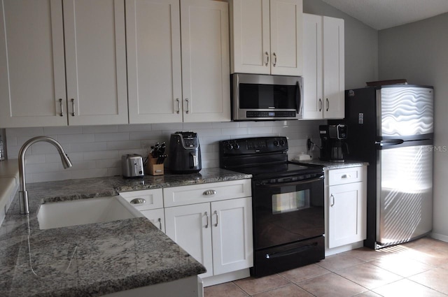 kitchen with sink, backsplash, stone counters, appliances with stainless steel finishes, and white cabinets