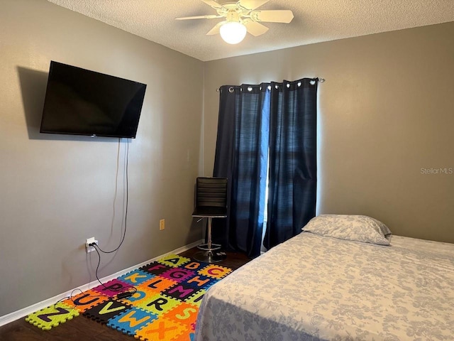 bedroom featuring ceiling fan, dark hardwood / wood-style flooring, and a textured ceiling