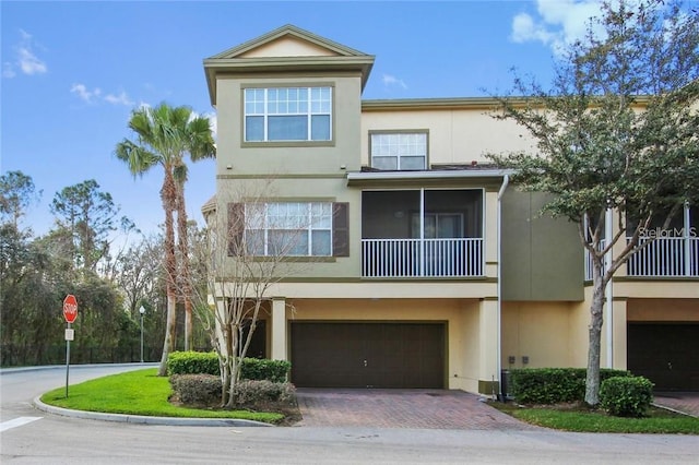 view of front of home featuring a garage, decorative driveway, and stucco siding