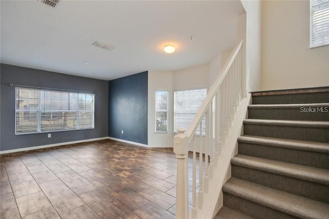 staircase featuring visible vents and baseboards