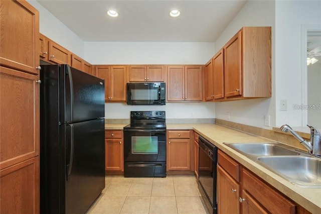 kitchen featuring brown cabinets, light countertops, a sink, and black appliances