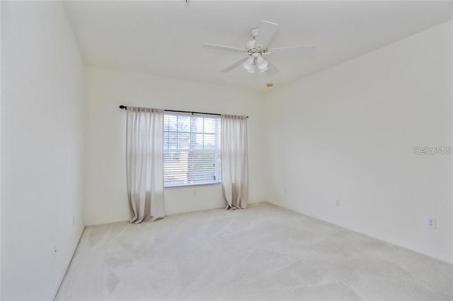 empty room featuring light colored carpet and ceiling fan