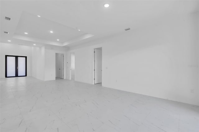 3924 NW 38th St, Cape Coral, FL 33993 - spare room featuring a tray ceiling, recessed lighting, french doors, and light marble finish flooring
