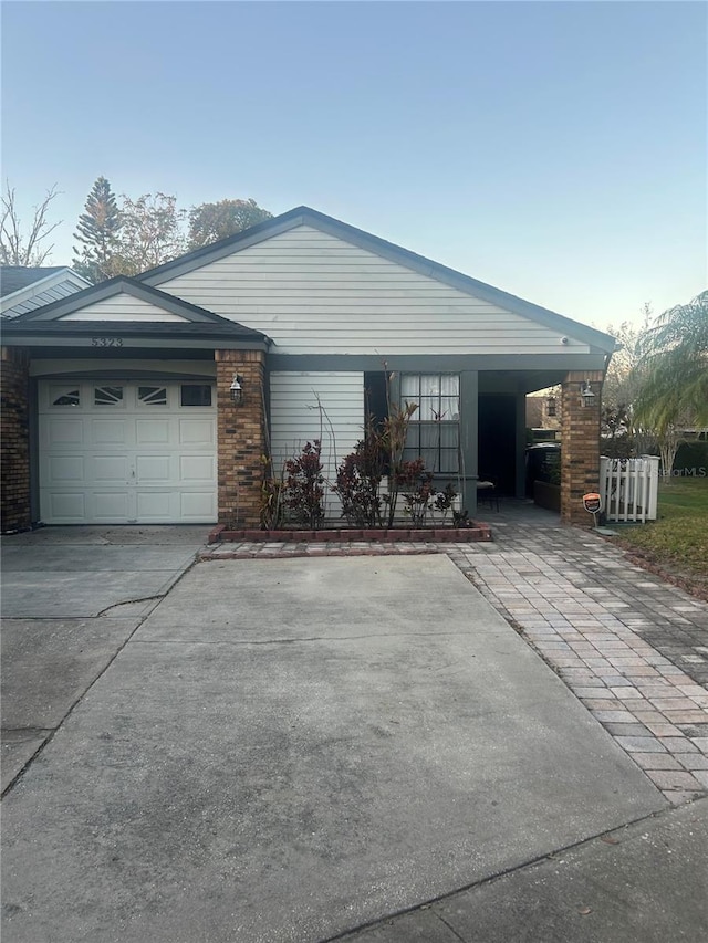 view of home's exterior featuring driveway, a garage, and brick siding