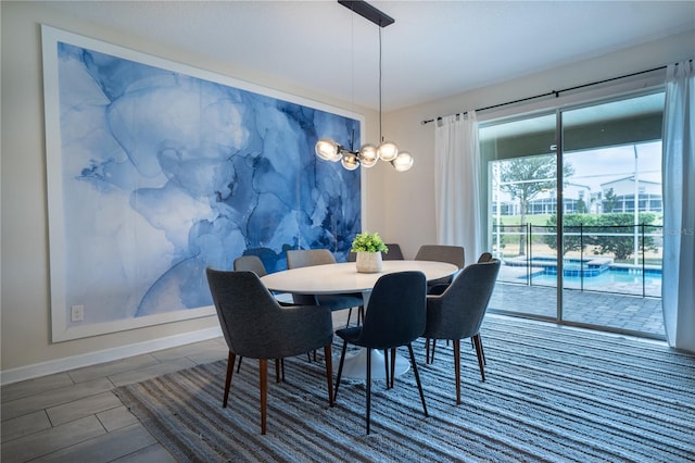 dining room with baseboards and an inviting chandelier