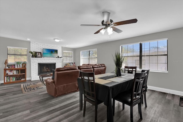 dining space featuring a fireplace, hardwood / wood-style floors, and ceiling fan