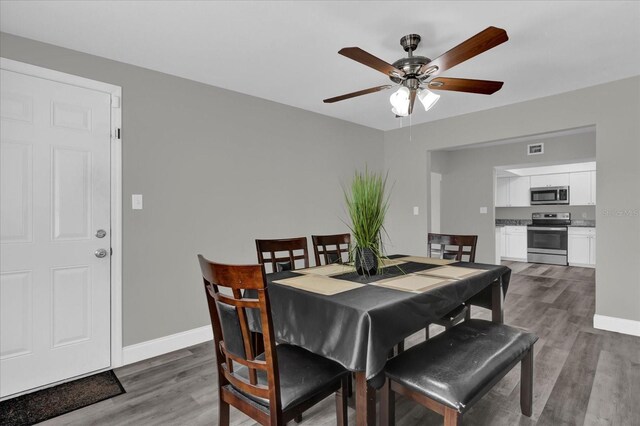 dining space with ceiling fan and dark hardwood / wood-style floors
