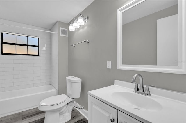 full bathroom featuring hardwood / wood-style floors, toilet, vanity, and tiled shower / bath