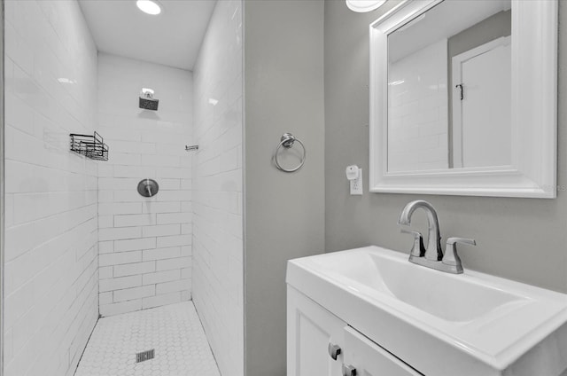 bathroom featuring tiled shower and vanity