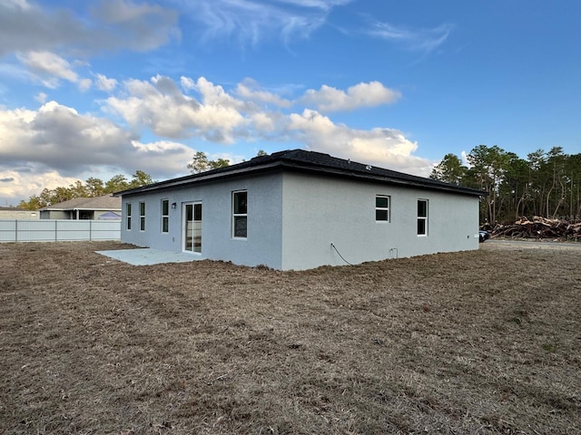 back of house featuring a patio area and a lawn