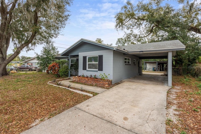 single story home with an attached carport, concrete driveway, and concrete block siding