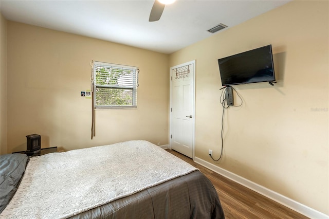 bedroom featuring dark wood-type flooring, visible vents, baseboards, and a ceiling fan