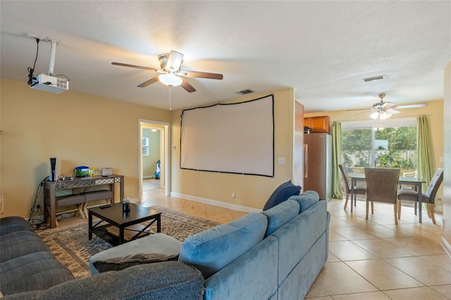 living area with a ceiling fan, visible vents, a textured ceiling, and light tile patterned floors