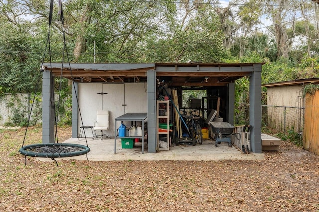 view of outdoor structure with fence and an outbuilding