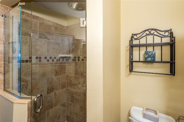 full bath featuring a stall shower and toilet