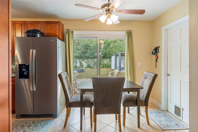 dining room featuring a ceiling fan, baseboards, and light tile patterned floors