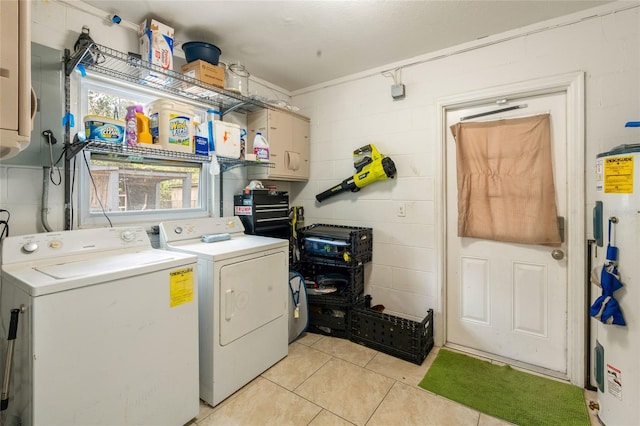 laundry room featuring concrete block wall, light tile patterned floors, water heater, washer and dryer, and laundry area