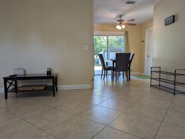 dining room featuring light tile patterned flooring, a ceiling fan, visible vents, and baseboards