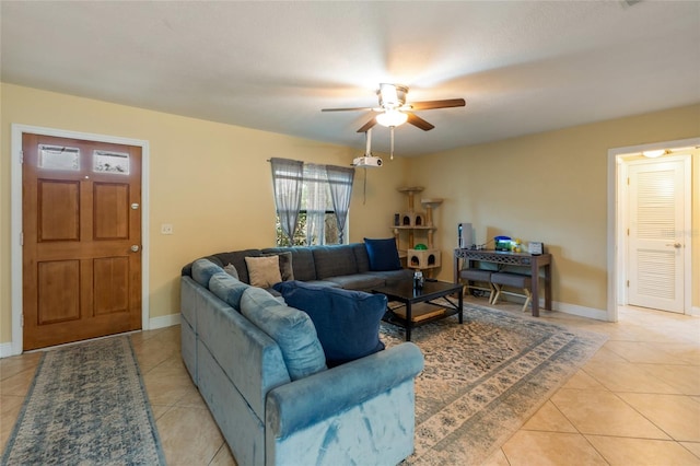 living area featuring light tile patterned flooring, a ceiling fan, and baseboards