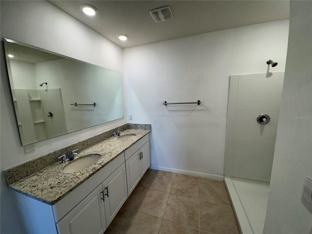 bathroom featuring tile patterned flooring, vanity, a textured ceiling, and walk in shower