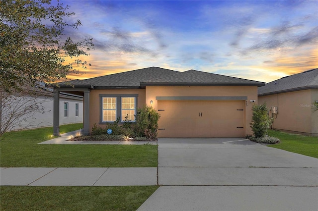 prairie-style home with a garage and a yard